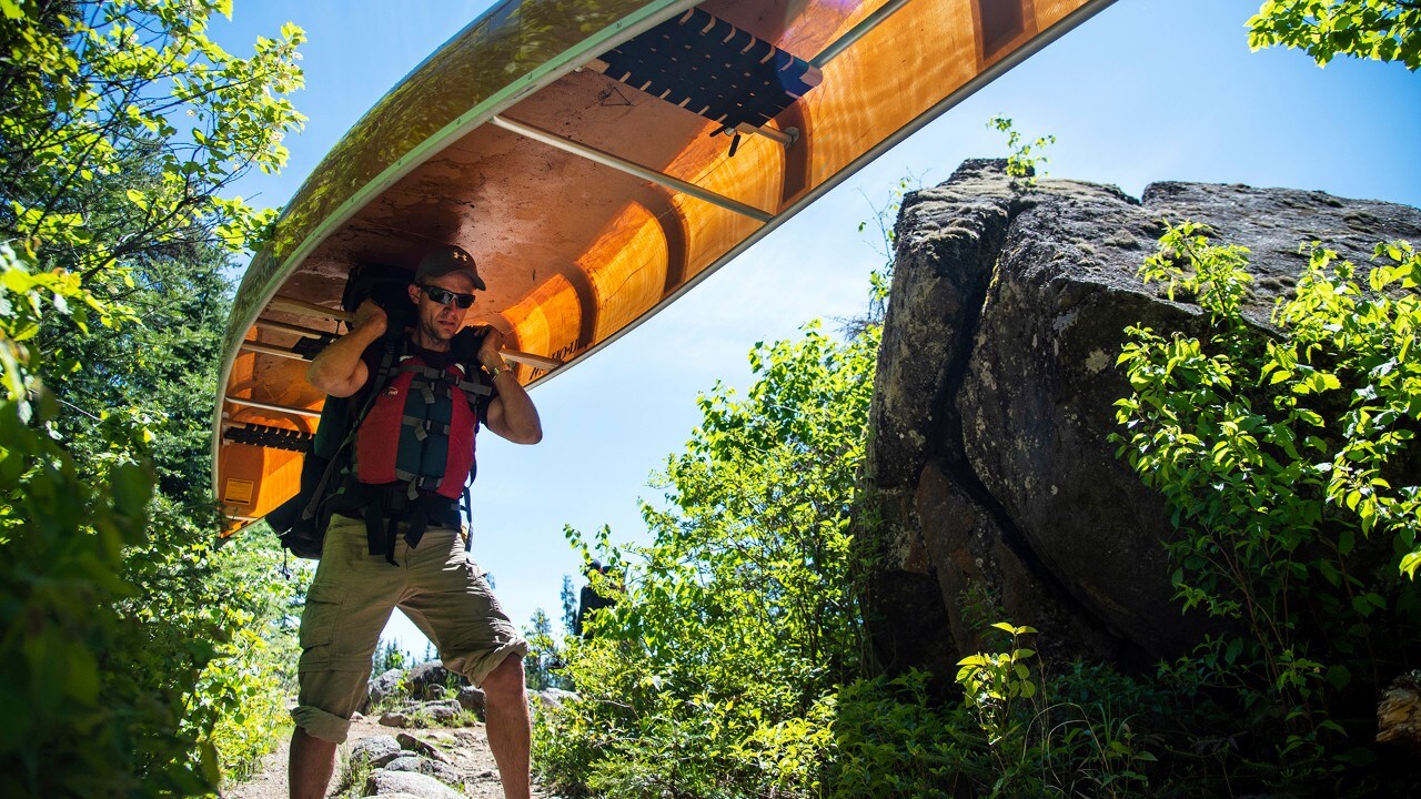 Peter portages the canoe from one lake to another, which is part of the BWCAW experience.