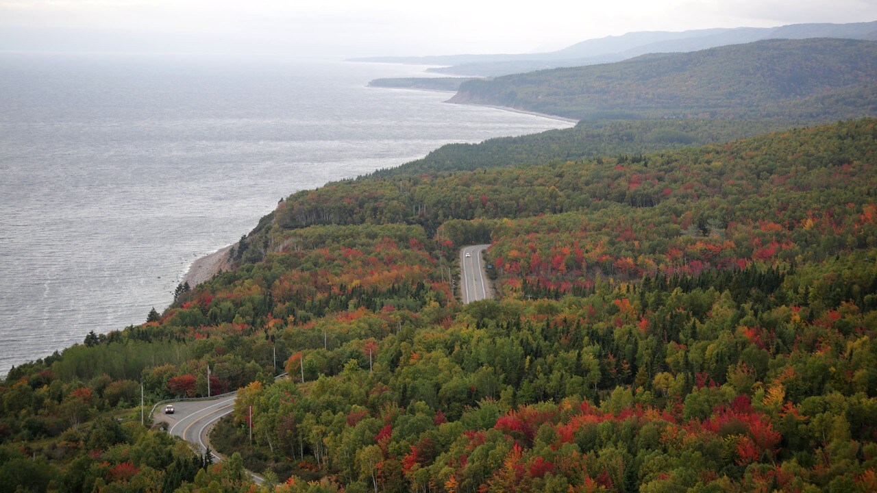 The drive near Ingonish winds through colorful trees.