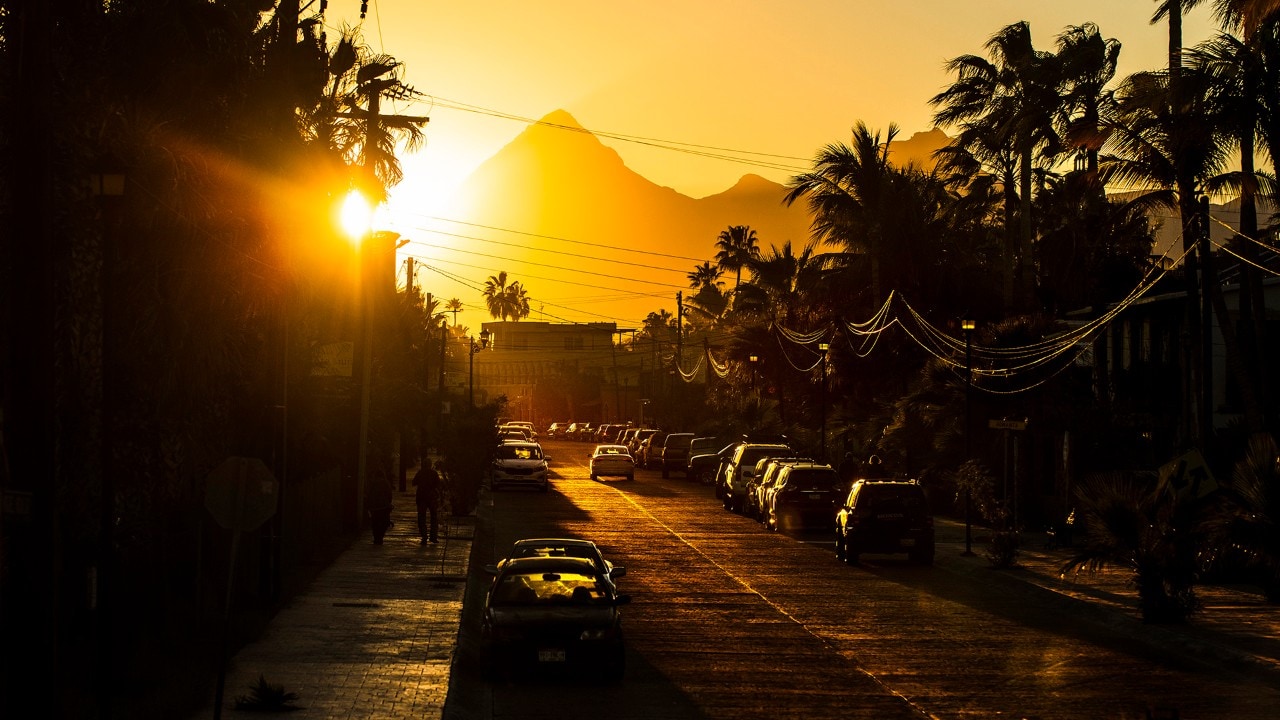 The sun sets behind the Sierra de la Gigantas, casting golden light across Loreto.