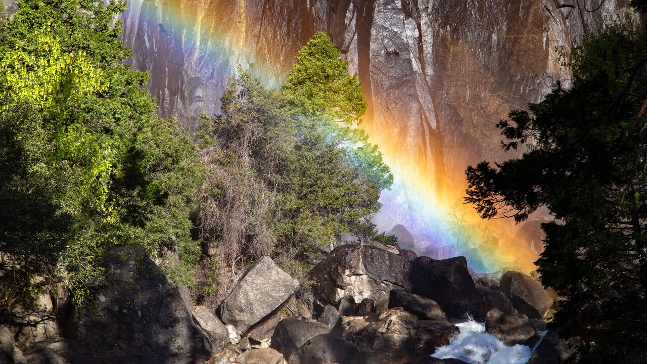 A rainbow appears in the mist of Lower Yosemite Falls. 