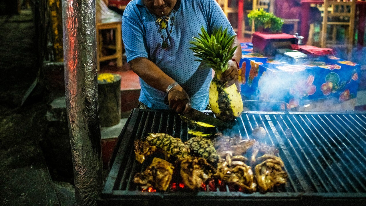 A chef grills chicken and pineapple at Pollos Los Pajaros in Pisté in Yucatán.