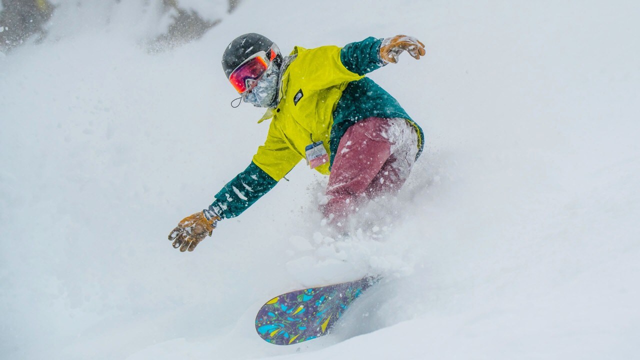 A snowboarder rides fresh snow at Lost Trail Powder Mountain in Montana. Photo by Nick Cote