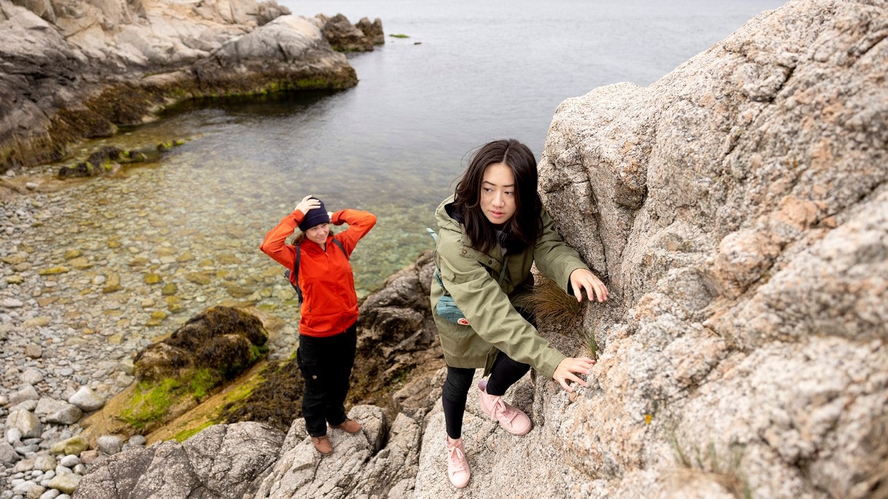 Author Kassondra Cloos (left) and Tammy To explore the rocky coast at Fort Wetherill State Park in Jamestown.