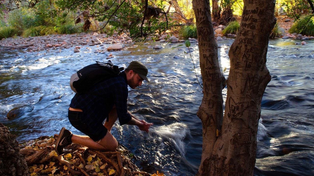 Kyle stops at Oak Creek to rinse red dust from his hands.