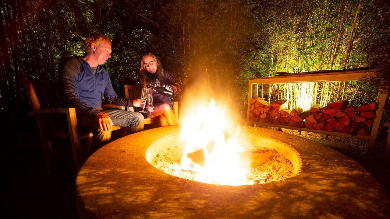 Brad and Tonya Clement enjoy champagne by firelight at their glamping accommodations at Manzanita, Oregon. Photo by Brad Clement