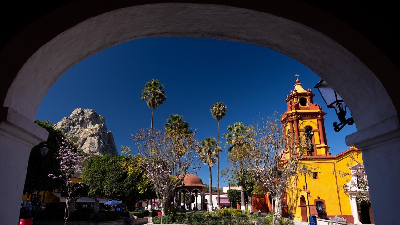 The 1,421 foot-tall monolith Pena de Bernal rises near the Templo de San Sebastián in Bernal.