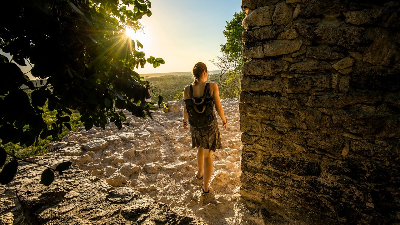 Kassondra explores the Nohoch Mul pyramid at the ancient Mayan city of Cobá.