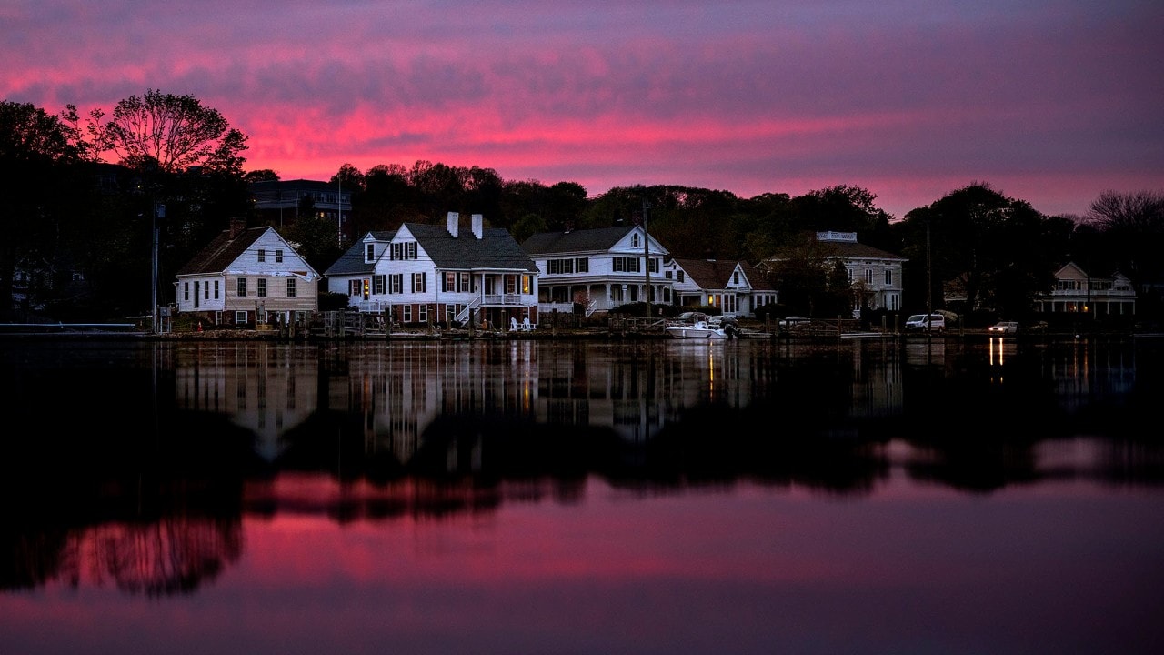 The sunset reflects in the Mystic River.