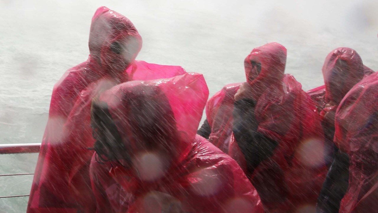 Visitors shelter from the spray at Horseshoe Falls.