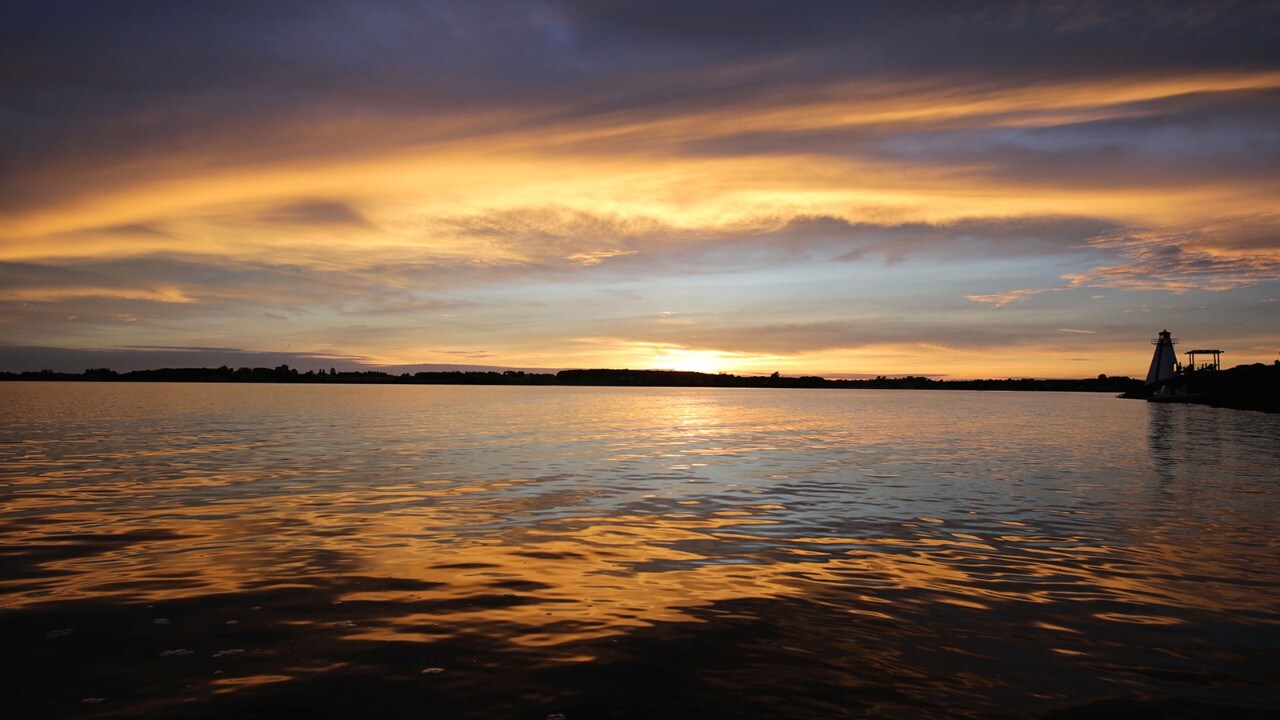 The sun sets on a lighthouse along the Victoria Park boardwalk in Charlottetown.