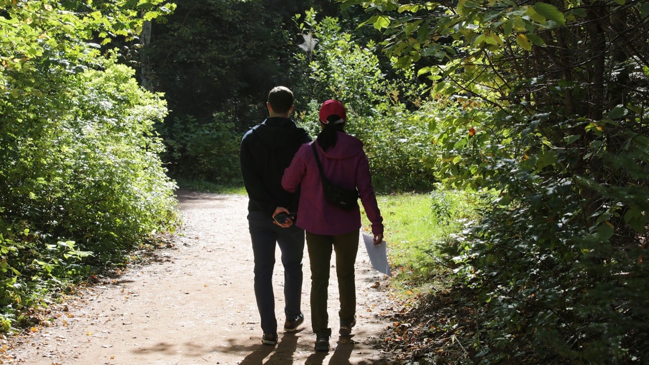 Two visitors stroll along Lover's Lane at Green Gables Heritage Place.