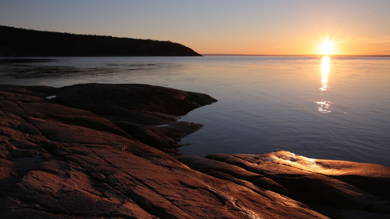 The sun rises above the St. Lawrence River at Tadoussac.