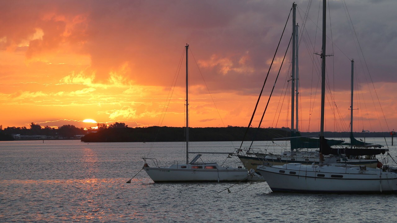 The sun rises over boats moored at Anna Maria Island. Photo by Charles Williams