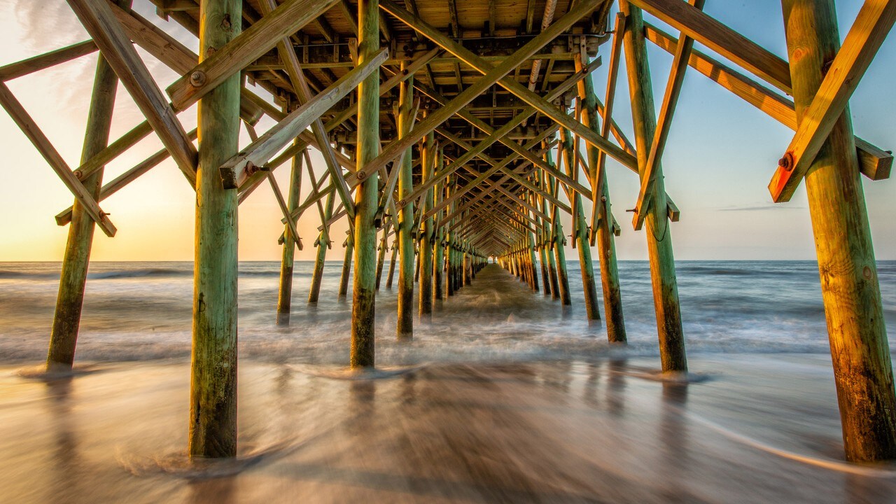 The Folly Beach Pier glows during sunrise.