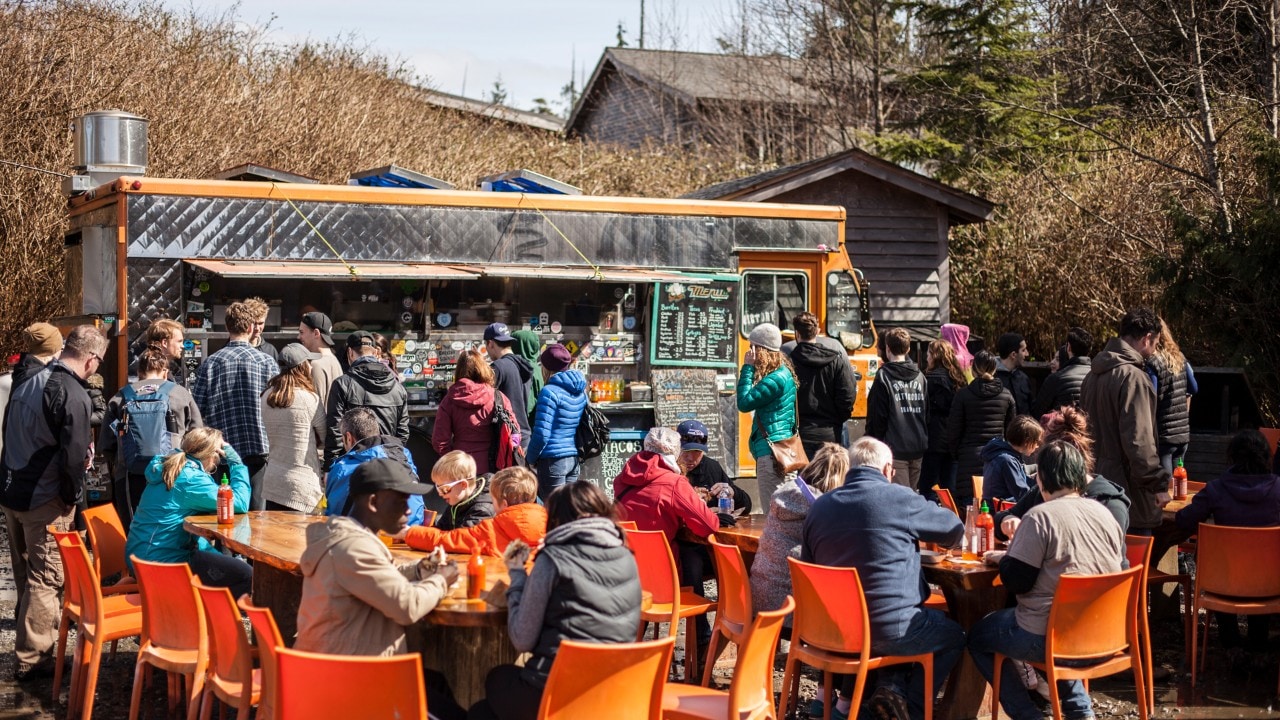 La gente se reúne en el camión de tacos Tacofino en Tofino, Canadá.