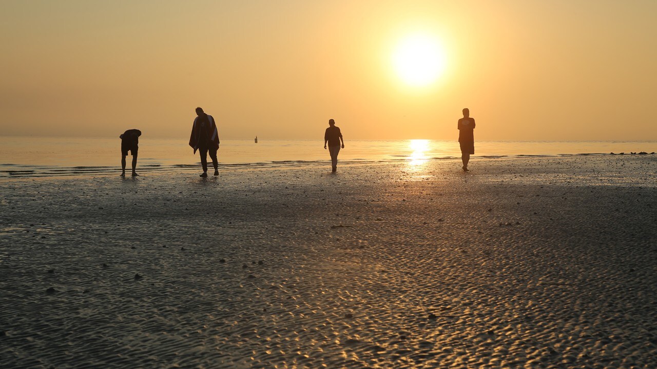 People beachcomb at Lighthouse Beach.