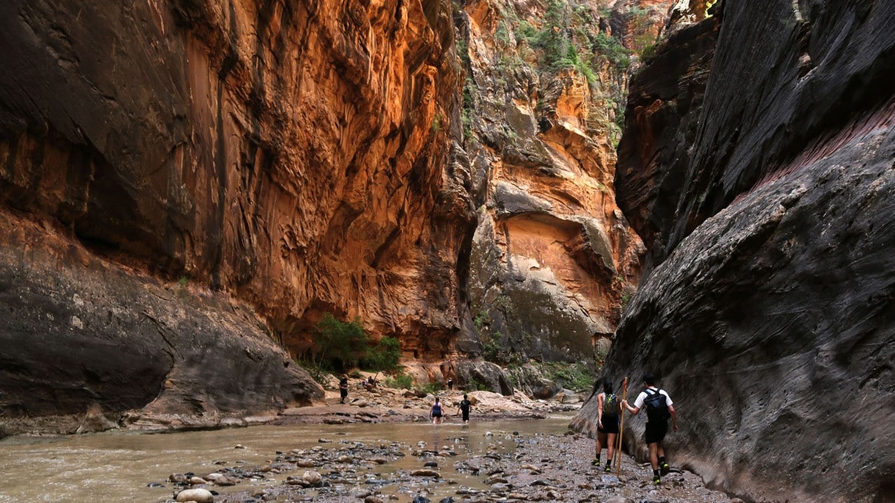 Hikers walk through The Narrows.